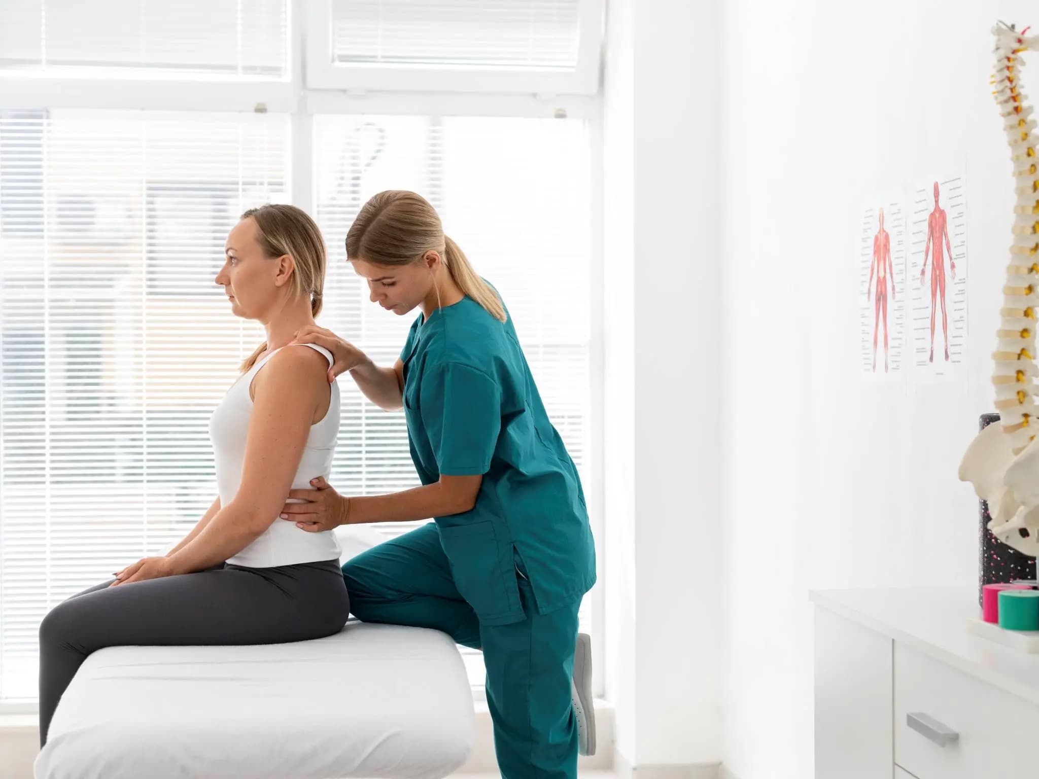Physiotherapist examining patient shoulder and back